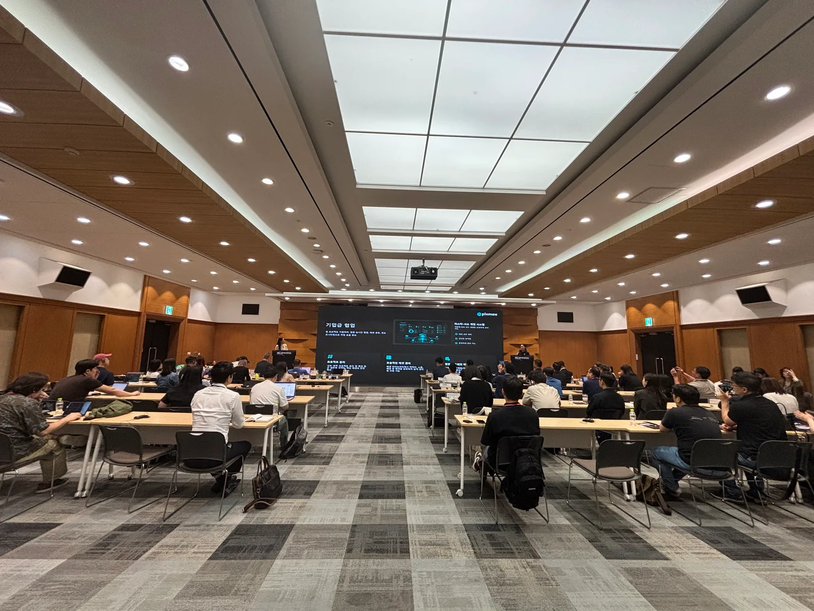 Pixmax keynote presentation at BCWW 2026 in Seoul with attendees seated in the conference room