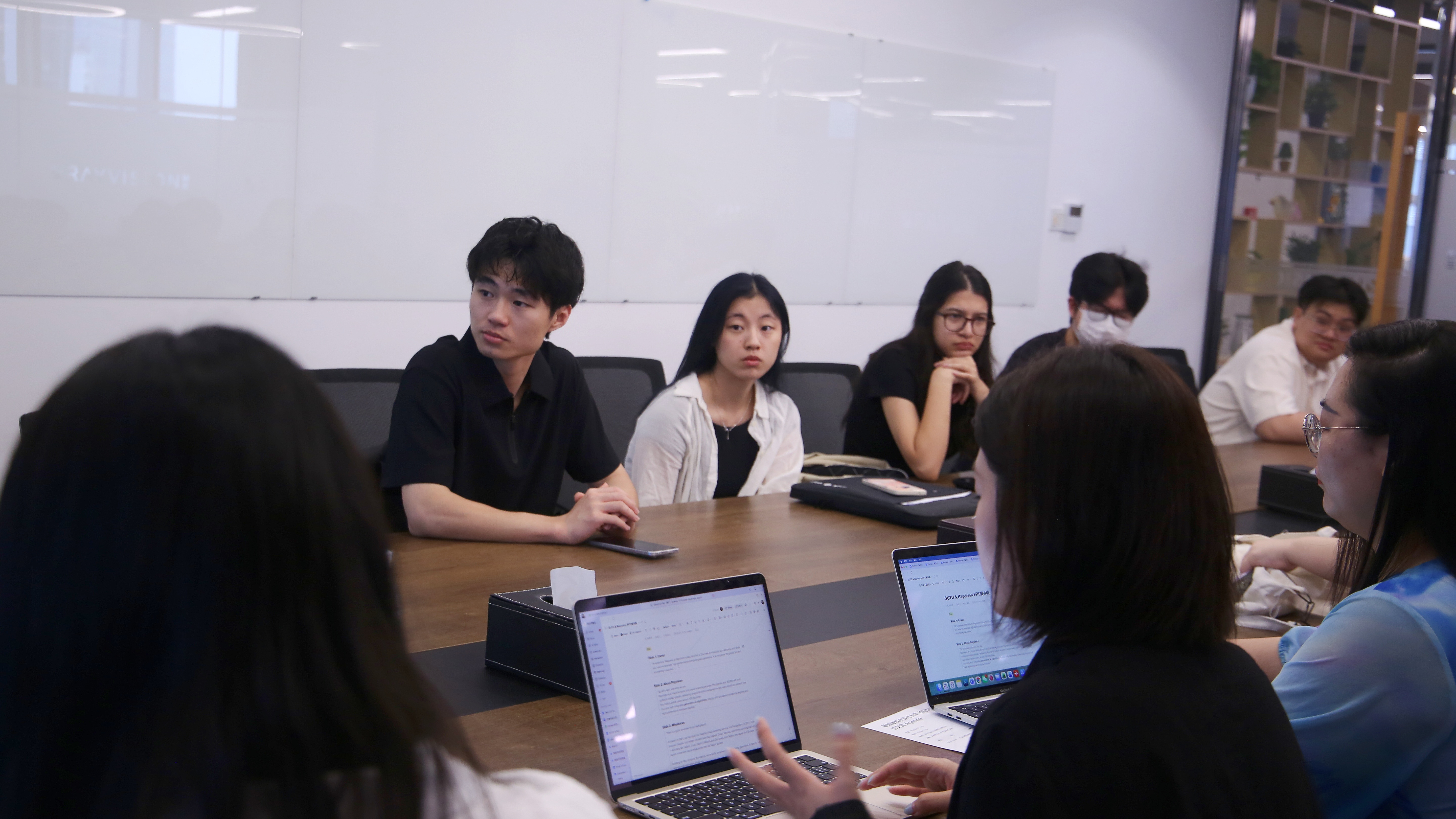 SUTD students discussing AI workflow concepts in the Pixmax meeting room